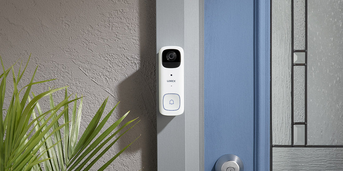 Lorex 2K battery-powered video doorbell mounted next to a front door, shown in a modern residential entryway setting.