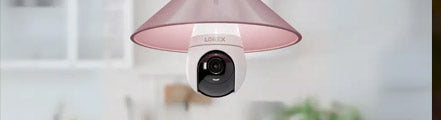 Lorex 2K Wi-Fi lightbulb security camera installed in a pink indoor ceiling fixture, offering smart surveillance and modern design for home monitoring.